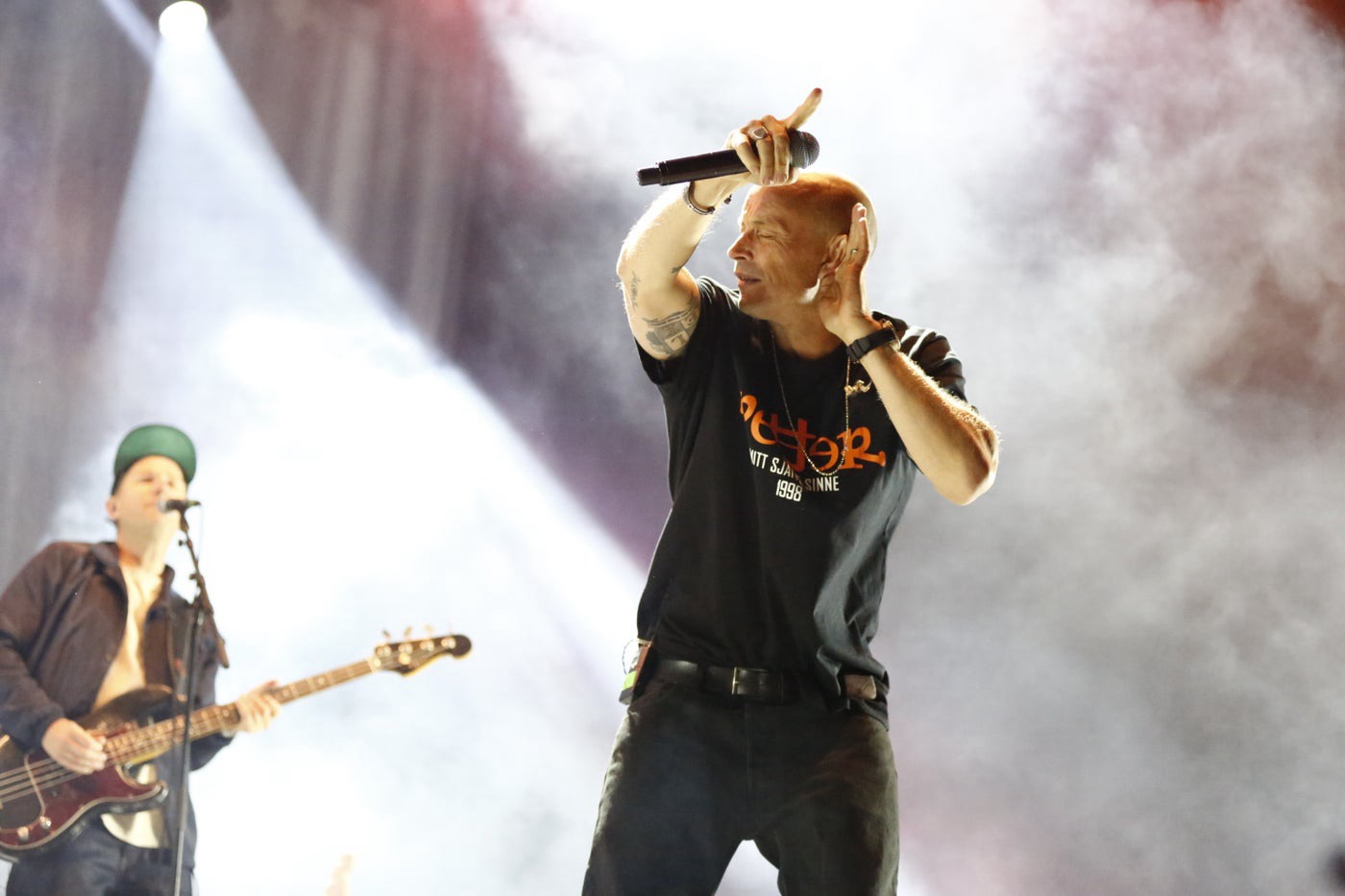 Rapper performing on stage in dramatic smoke and light